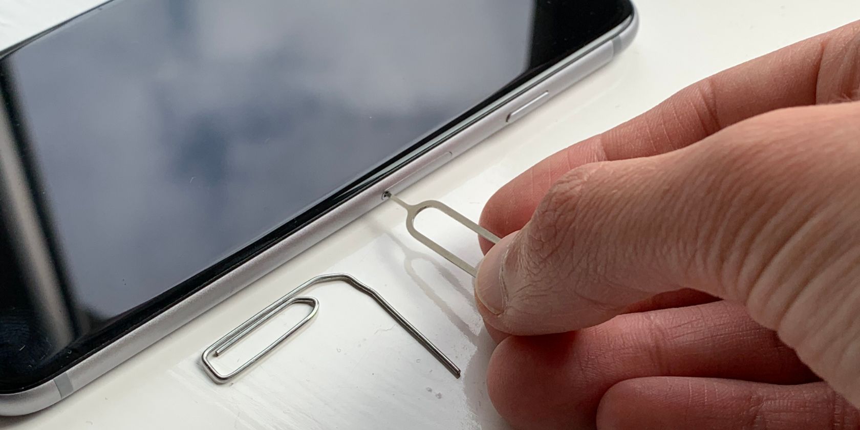 SIM removal tool inserted into slot - Come rimuovere una scheda SIM da un iPhone